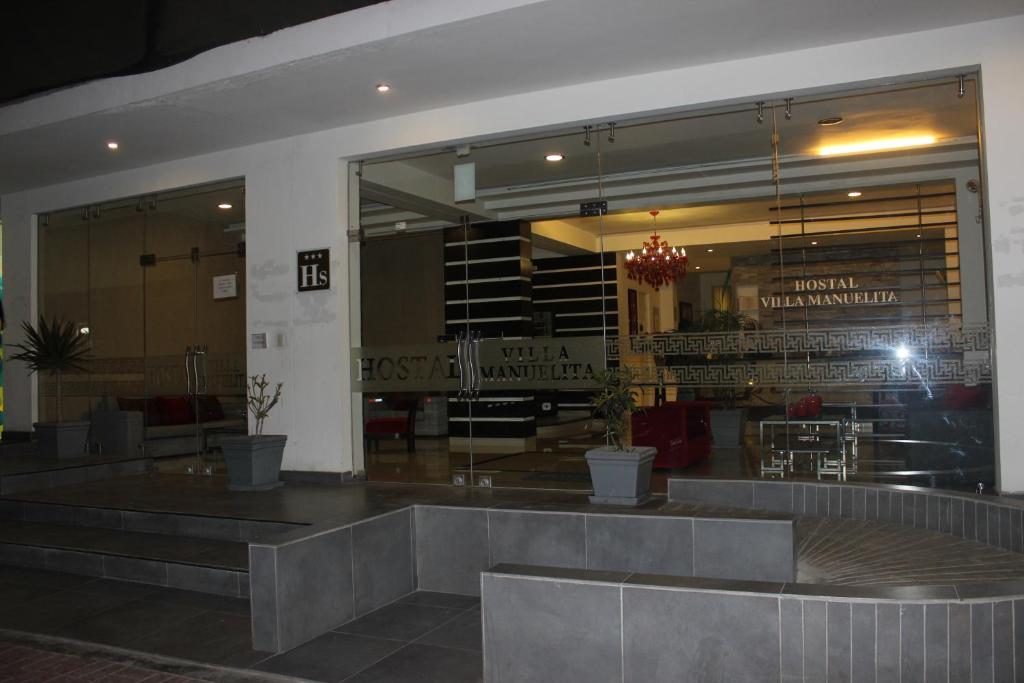 um restaurante com bancos em frente a um edifício em Hostal Villa Manuelita em Pisco