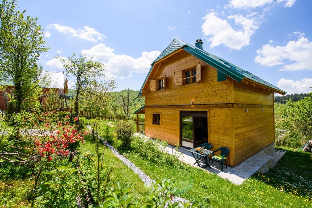 una pequeña casa de madera en un jardín en Sterling Lodge en Kolašin