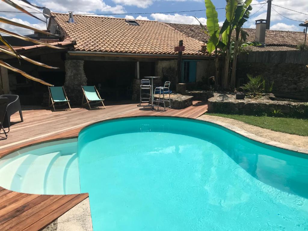 una piscina con terraza y una casa en Guesthouse Simon Carretey SAUNA & SWIMMING-P, CALM, en Barsac