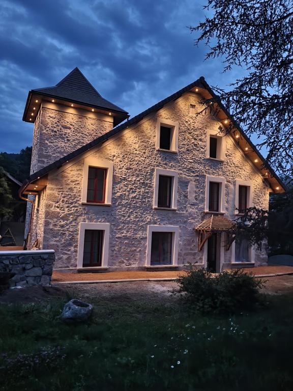 a large stone building with lights on it at La Tour de Coron in Belley