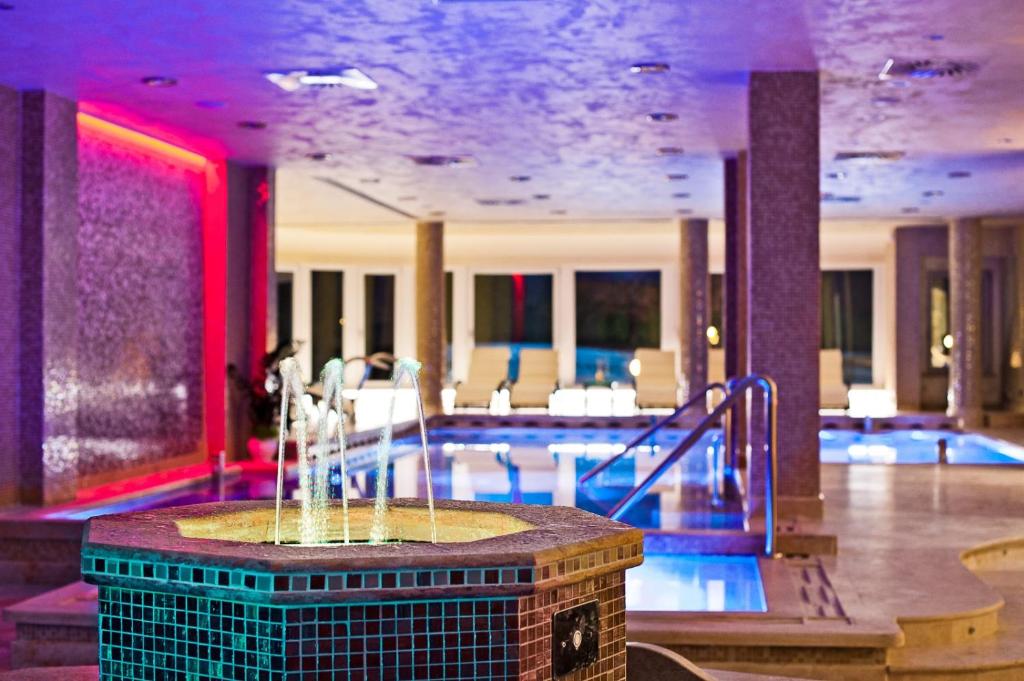 a swimming pool with a fountain in a hotel lobby at Hotel Fiuggi Terme Resort & Spa in Fiuggi