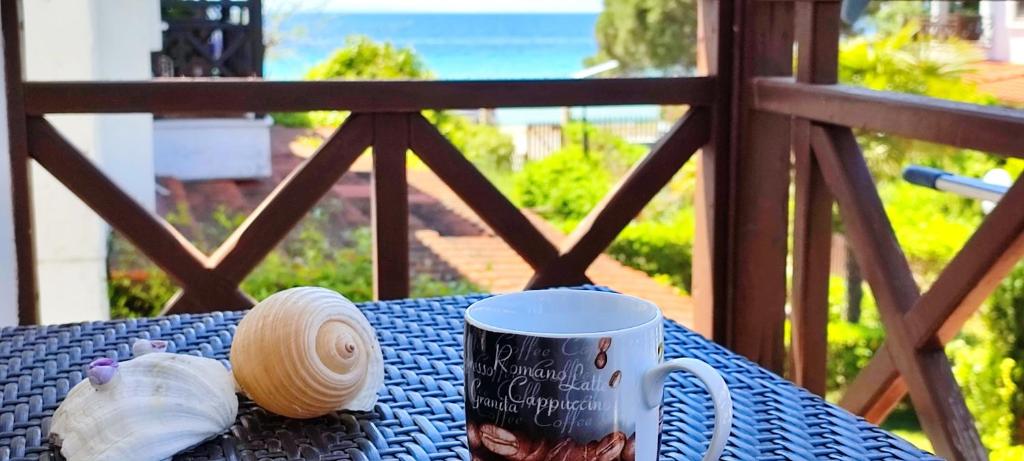 a coffee cup sitting on a table with a view of the ocean at The SeaSide Villas in Nikiti