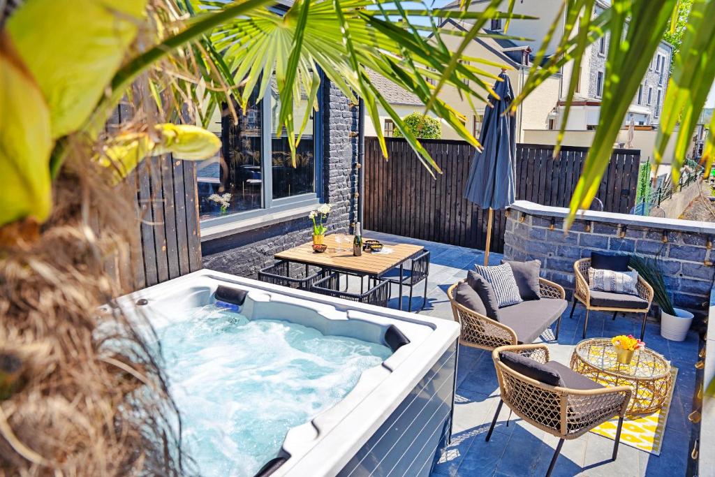 - un bain à remous sur une terrasse avec des chaises et une table dans l'établissement Gatsby River I, à Yvoir