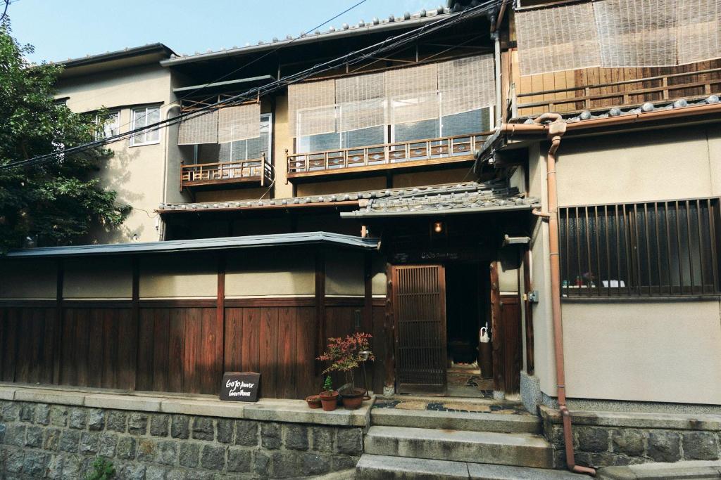 a building with a gate and stairs in front of it at Gojo Guesthouse - Annex in Kyoto