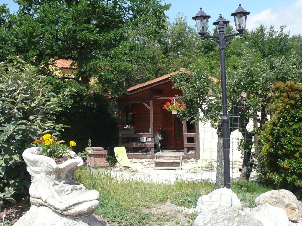 a garden with a lamp post and a house at Les chalets du Verger des Ascarines in Corneilla-de-Conflent