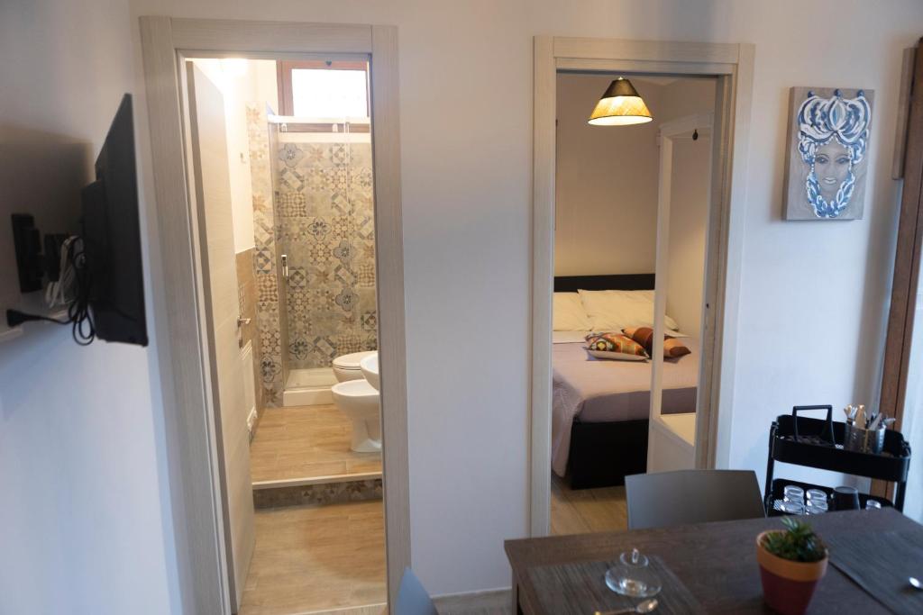 a room with a bedroom with a bed and a bathroom at MrBrown - Cinzia Resort Beach in Mazara del Vallo