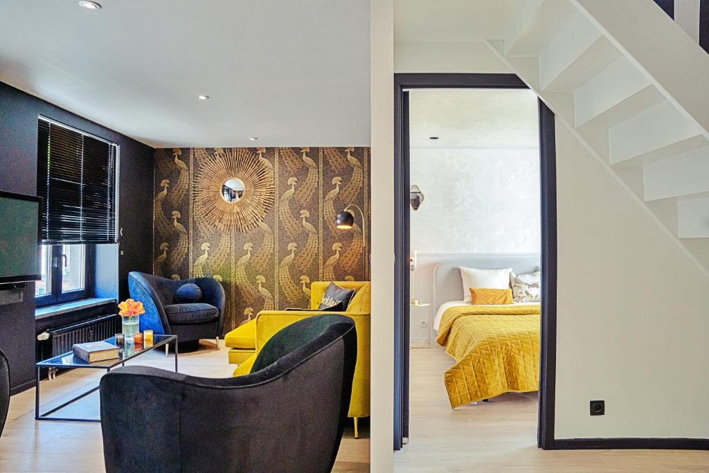 um quarto e uma sala de estar com uma cama e um espelho em Gatsby River II em Yvoir