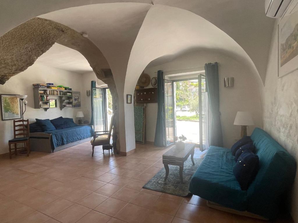 sala de estar con sofá azul y mesa en Luberon maison de village entière 2 à 6 personnes, en Cabrières-dʼAigues