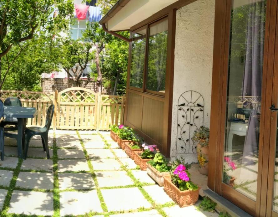 een patio met een tafel, stoelen en bloemen bij Villino L'Aranceto Sorrentino in Meta