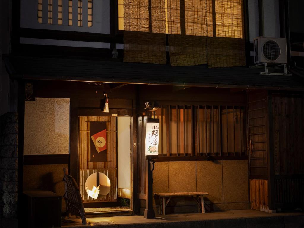 an entrance to a building with a table and a bench at naokonoza Bettei Umekoji in Kyoto