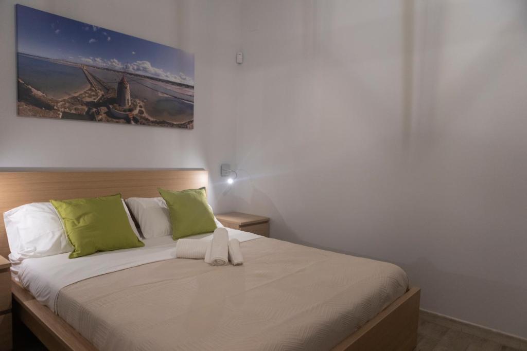 a bedroom with a bed with green and white pillows at MrBrown - Cinzia Resort Beach in Mazara del Vallo