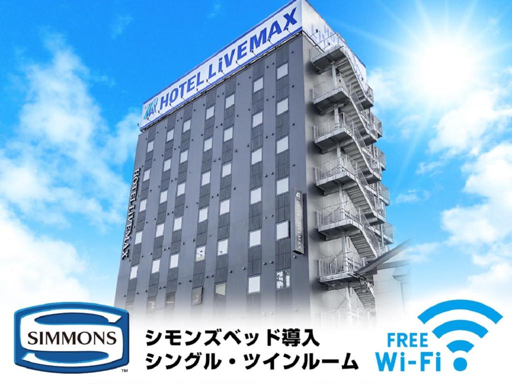 un edificio con un cartel en el costado en HOTEL LiVEMAX Niigata Ekimae en Niigata