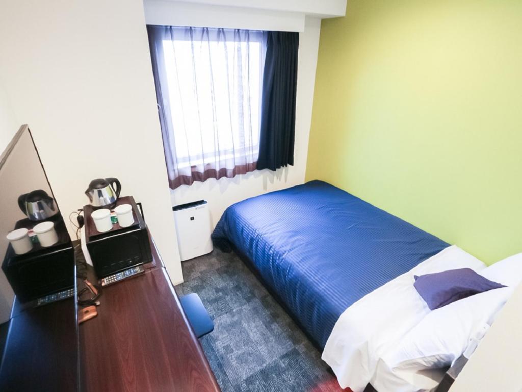 Postel nebo postele na pokoji v ubytování HOTEL LiVEMAX Niigata Ekimae