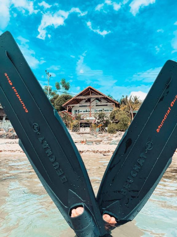 a person holding two skis in the water at Serenity Luxurious Beachfront Villa & Spa with private Infinity Pool, 8 Guests in Gili Air