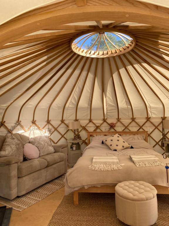 a room with a bed and a window in a yurt at The Yurt @ Osmore in Axminster
