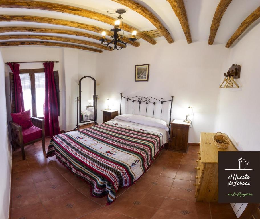 ein Schlafzimmer mit einem Bett in einem Zimmer mit Decken in der Unterkunft El Huerto de Lobras in Lobras