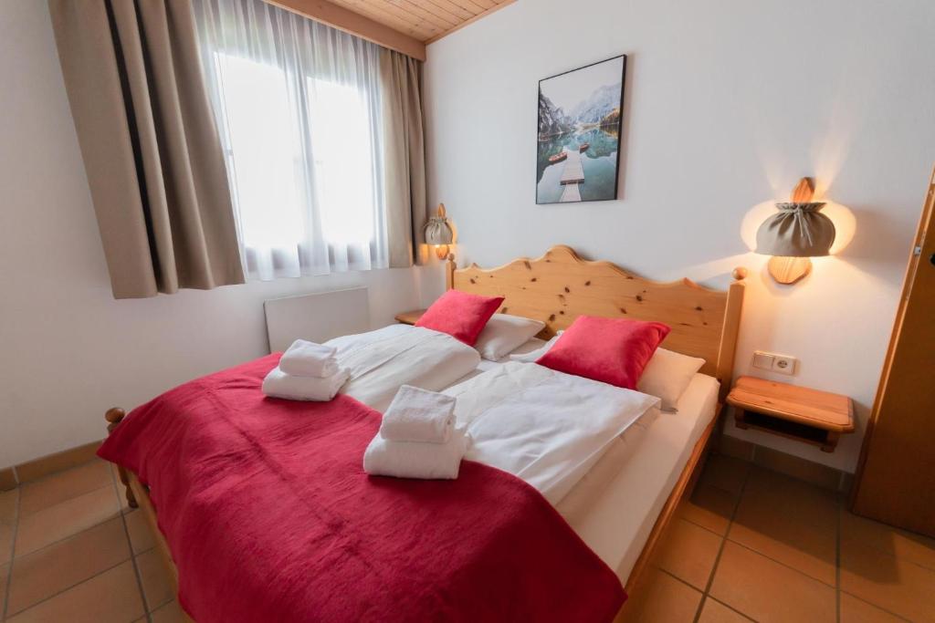 a bedroom with a large bed with red and white sheets at Apartment Panorama Gerlitzen in Treffen