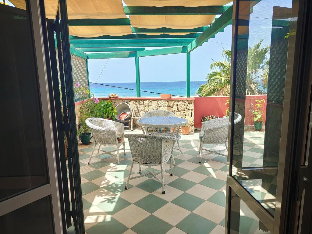 un patio con tavolo, sedie e vista sull'oceano di Albis Harena - Ibiscus Attico Ocean View a Santa Maria