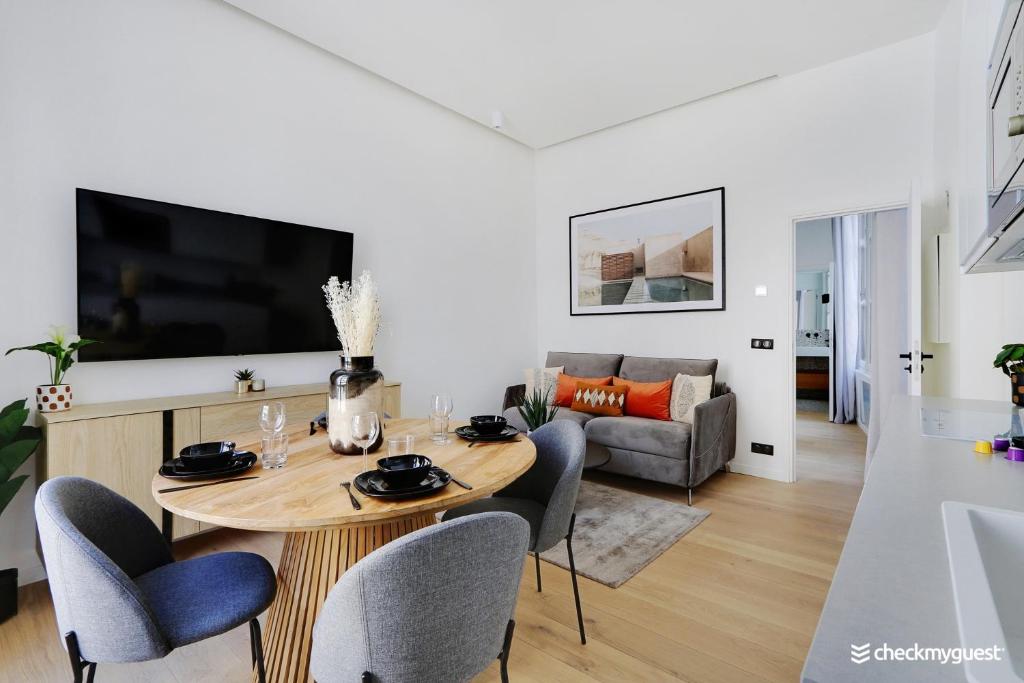 un salon avec une table, des chaises et une télévision dans l'établissement Beautiful apartment 1BR-4P - Le Marais, à Paris