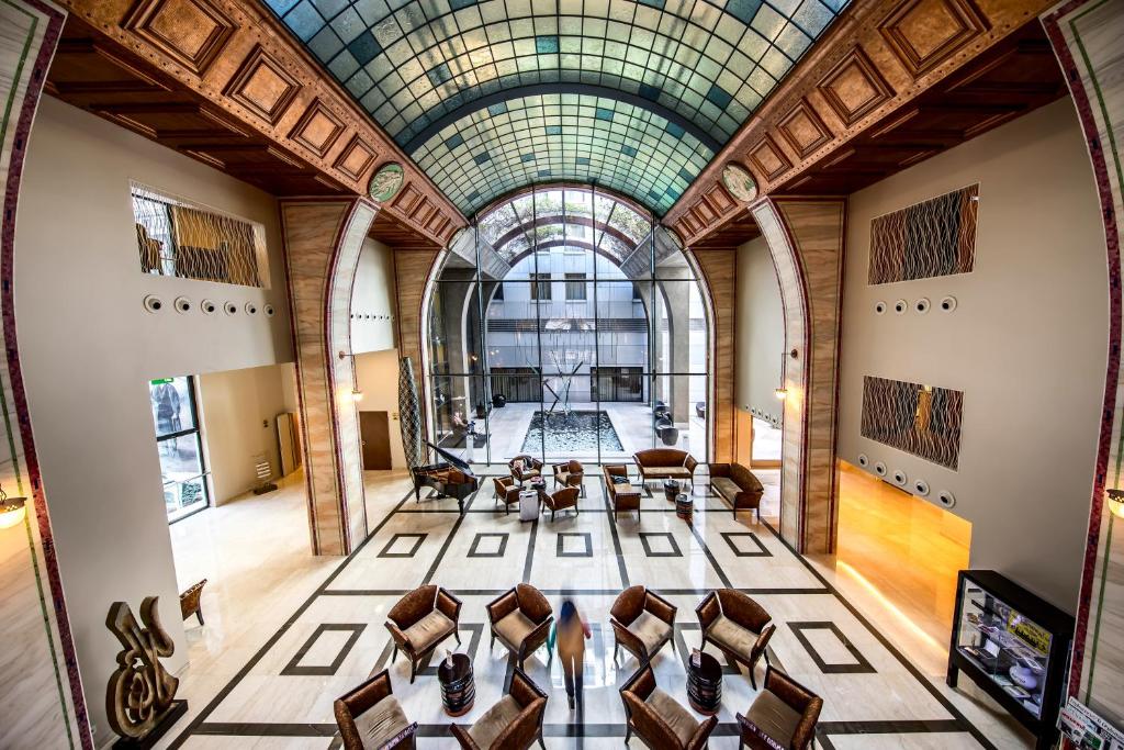 une salle de conférence avec des chaises et un plafond en verre dans l'établissement Continental Hotel Budapest, à Budapest