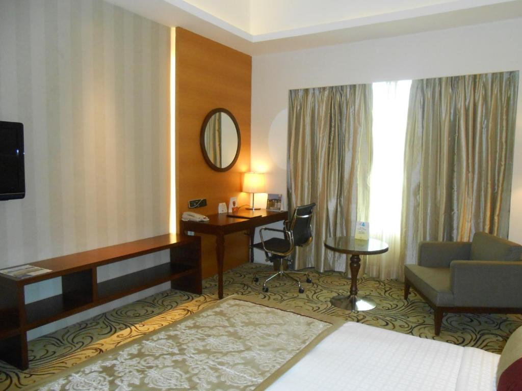 Postel nebo postele na pokoji v ubytování Pride Plaza Hotel, Kolkata