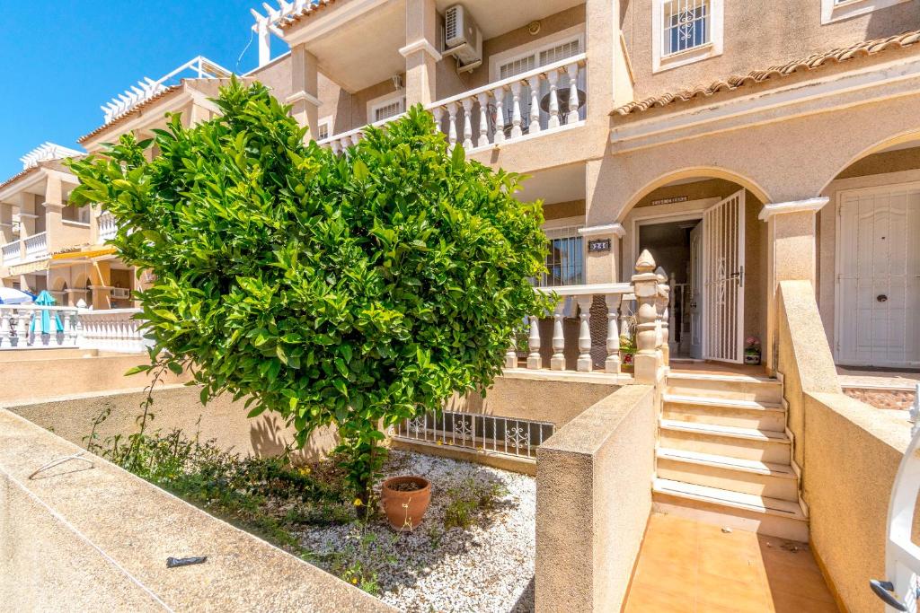 a tree in front of a building with a staircase at HE Paola 2 in Orihuela Costa