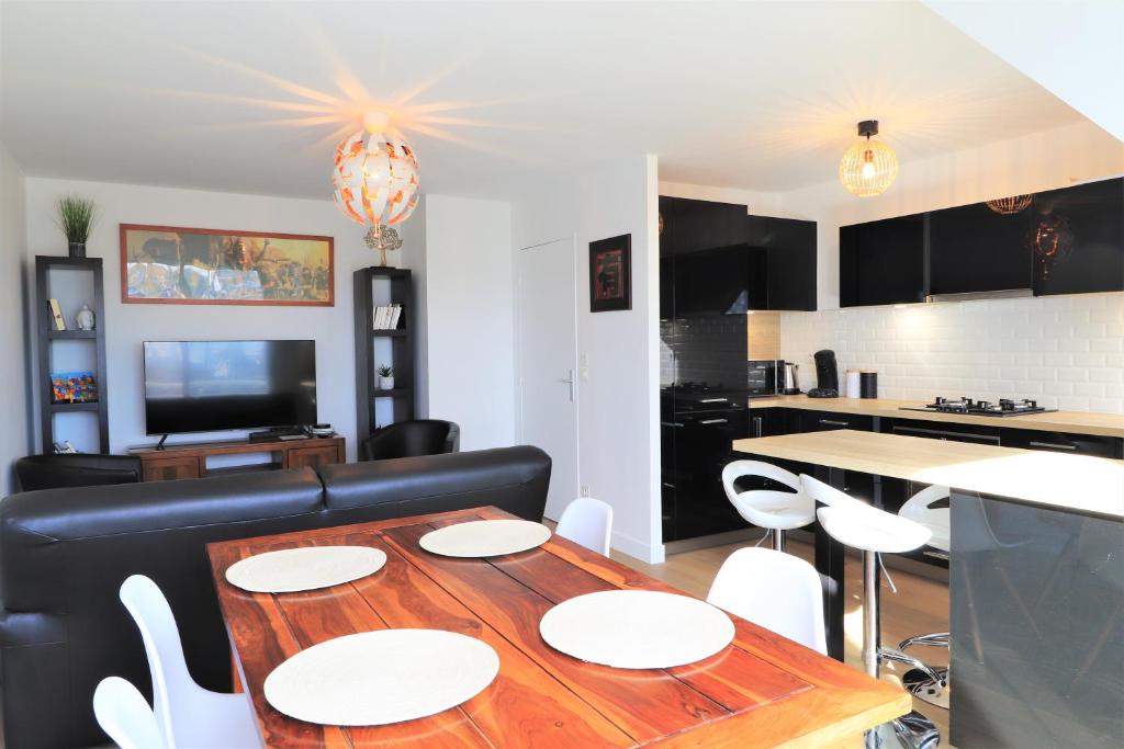 ein Esszimmer und eine Küche mit einem Tisch und Stühlen in der Unterkunft LE BONDON in Vannes
