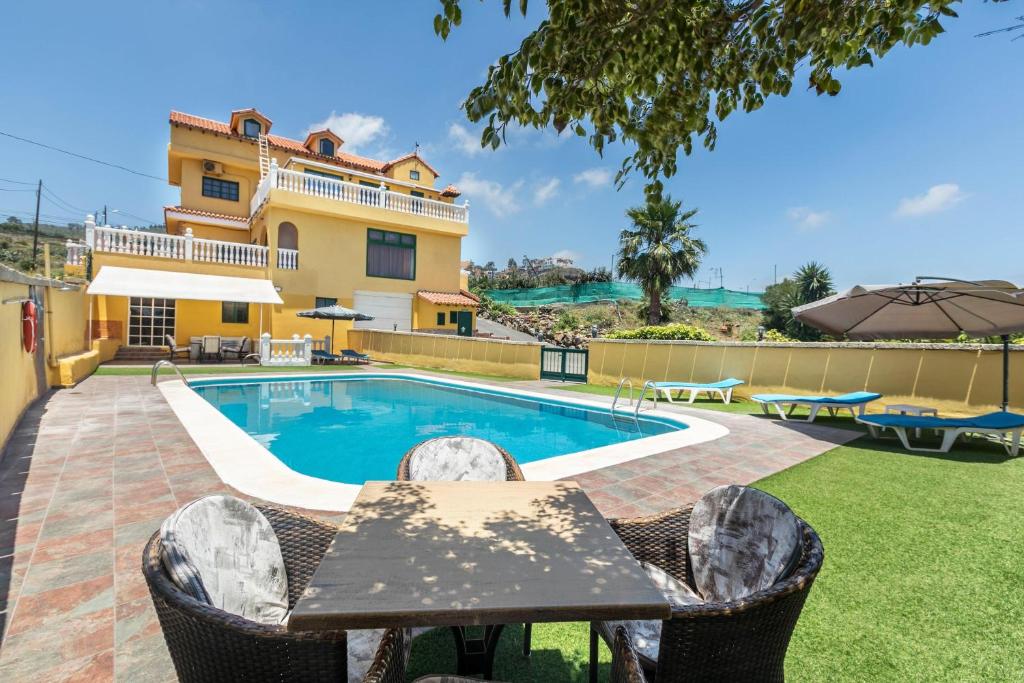 a villa with a swimming pool and a house at Buhardilla Armonia Rural in Granadilla de Abona