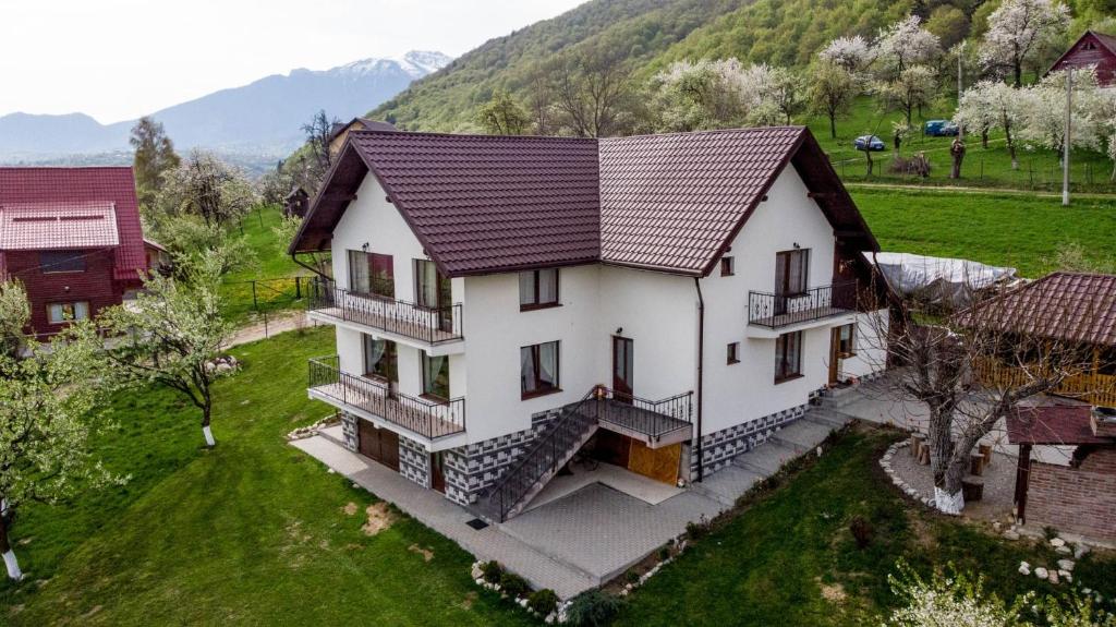 an overhead view of a white house with mountains in the background at Casa din Livada in Predeluţ