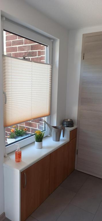 eine Küche mit einem Fenster mit einem Blind drauf in der Unterkunft Ferienwohnung am Vareler Hafen/ Nordsee in Varel