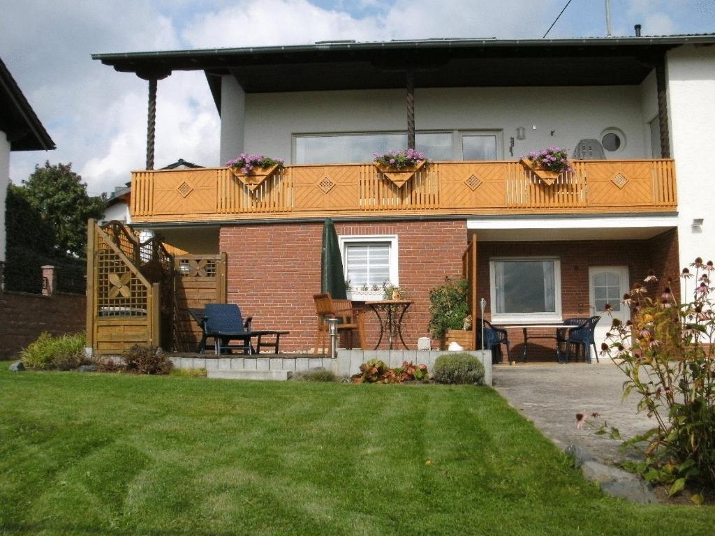 a house with a deck and a yard at Ferienwohnung Kaiser in Reifferscheid