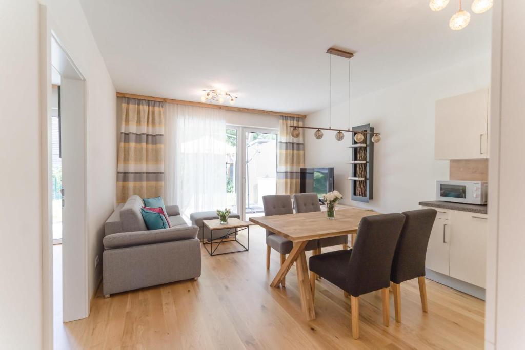 a kitchen and dining room with a table and chairs at Apartments Oasis Wörthersee neu & zentral in Krumpendorf am Wörthersee