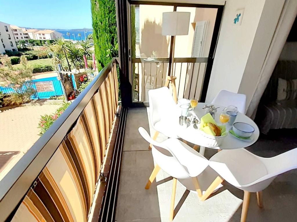 uma mesa branca e cadeiras numa varanda com vista em Appartement Six-Fours-les-Plages, 2 pièces, 4 personnes - FR-1-316-274 em Six-Fours-les-Plages