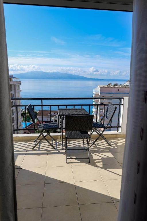 a balcony with a table and chairs and a view of the ocean at Albania Dream Apartment 31 in Metogjashta