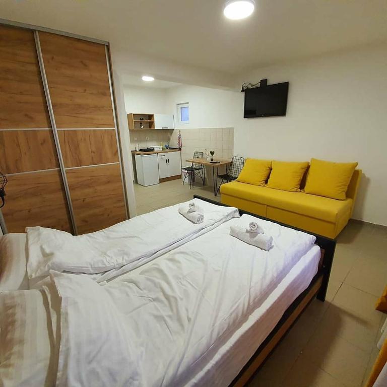 a room with a bed and a yellow couch at Apartmani Naumovi 2 in Star Dojran