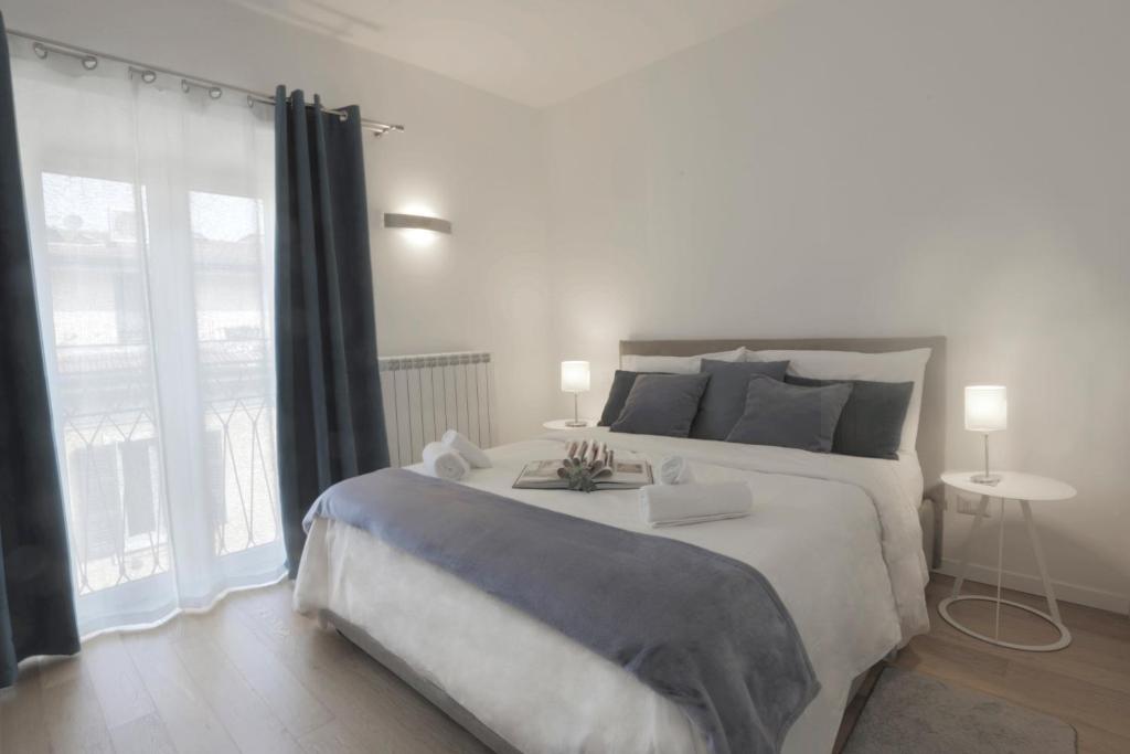 ein Schlafzimmer mit einem großen Bett und einem großen Fenster in der Unterkunft Il Cortile di Milano in Mailand