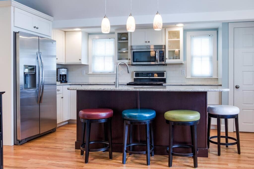 a kitchen with a counter with four stools at Beautiful & Romantic 1BR Cottage in Ocean Grove