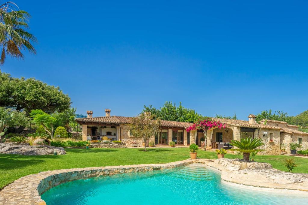 een huis met een zwembad voor een tuin bij Villa Can Brullet by SunVillas Mallorca in Pollença