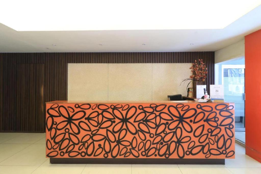 una oficina con un patrón naranja en la pared en Urbanview Hotel Mroom PH, en Yakarta