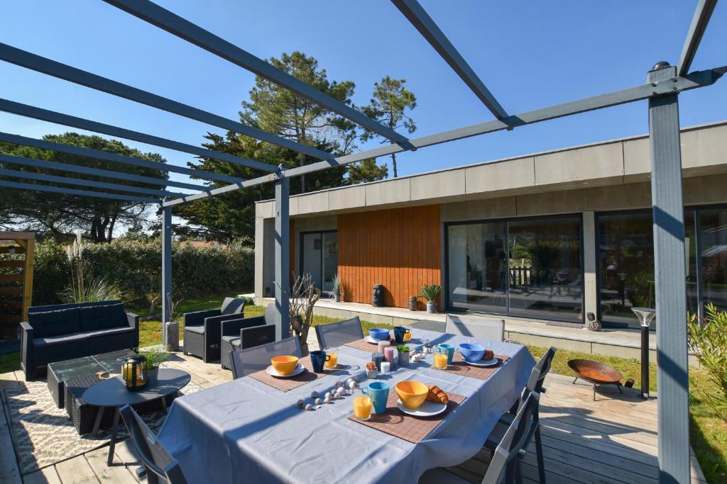 uma área de refeições exterior com mesas e cadeiras azuis em Le Lodge em Saint-Jean-de-Monts