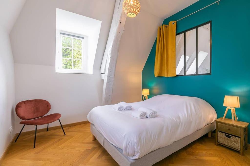 um quarto com uma cama, uma cadeira e uma janela em Le notre dame em Dijon
