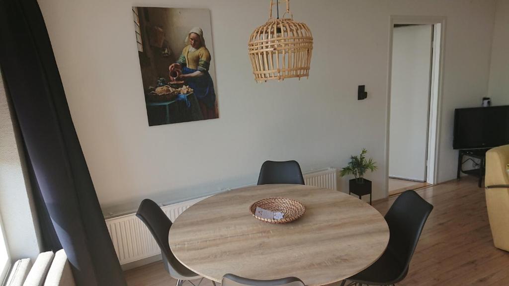 een houten tafel en stoelen in de woonkamer bij Plattedijk - vakantiehuis 25-26 in Lemmer