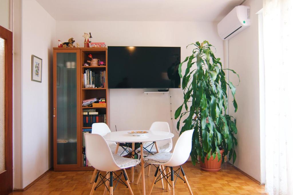 ein Esszimmer mit einem weißen Tisch und einer Pflanze in der Unterkunft Apartment Todorović - Macan in Pula