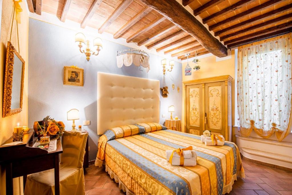 een slaapkamer met een groot bed en een gele deken bij B&B Il sogno del musicista in Montalcino