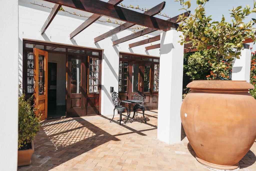 eine große Vase auf einer Terrasse mit einem Gebäude in der Unterkunft Mitre's Edge Vineyard Studio in Klapmuts