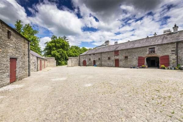 a large stone barn with a large driveway at 2 Bed Courtyard Apartment at Rockfield House Kells in Meath - Short Term Let in Kells