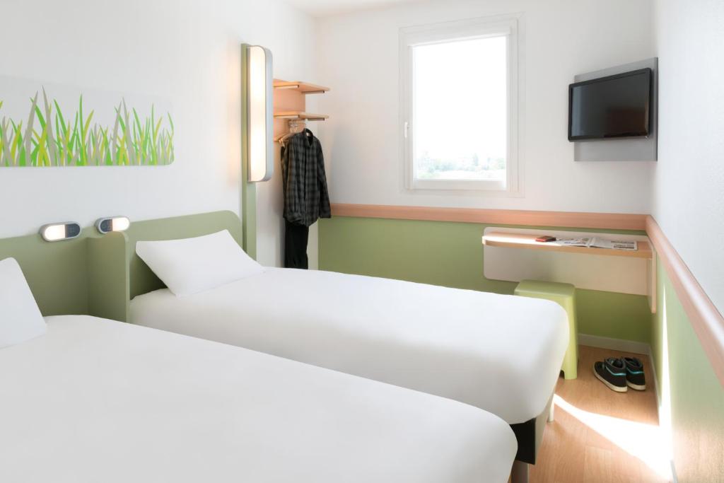 Postel nebo postele na pokoji v ubytování Hotel Ibis Budget Lyon Eurexpo -
