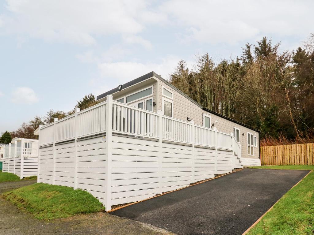 una casa blanca con una valla blanca en Denbigh 8, en Borth