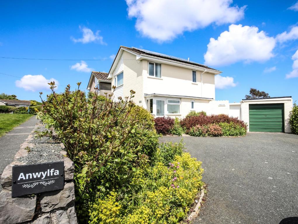 a house with aania sign in front of a driveway at Anwylfa in Moelfre
