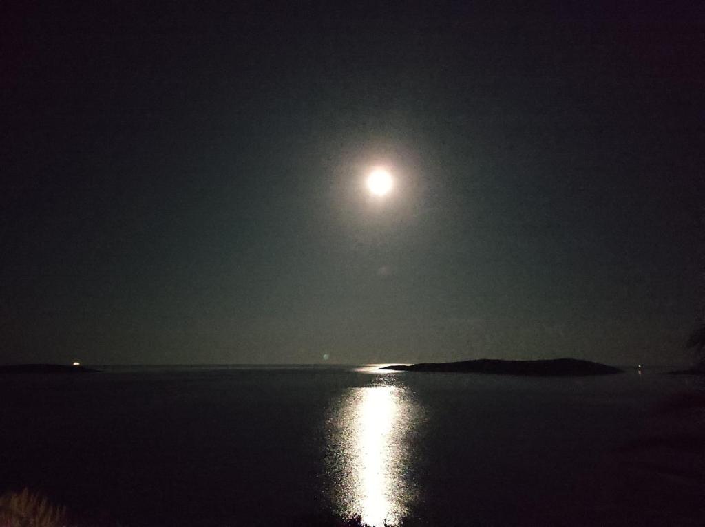 a full moon over a body of water at night at Getaway house Gundula in Podstražje